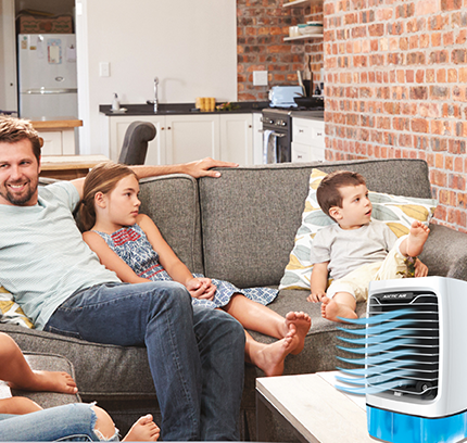 Family sitting on couch with Arctic Air® Chill Zone XL cooling the room