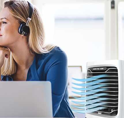 Woman working on computer with Arctic Air® Chill Zone XL blowing cool air
